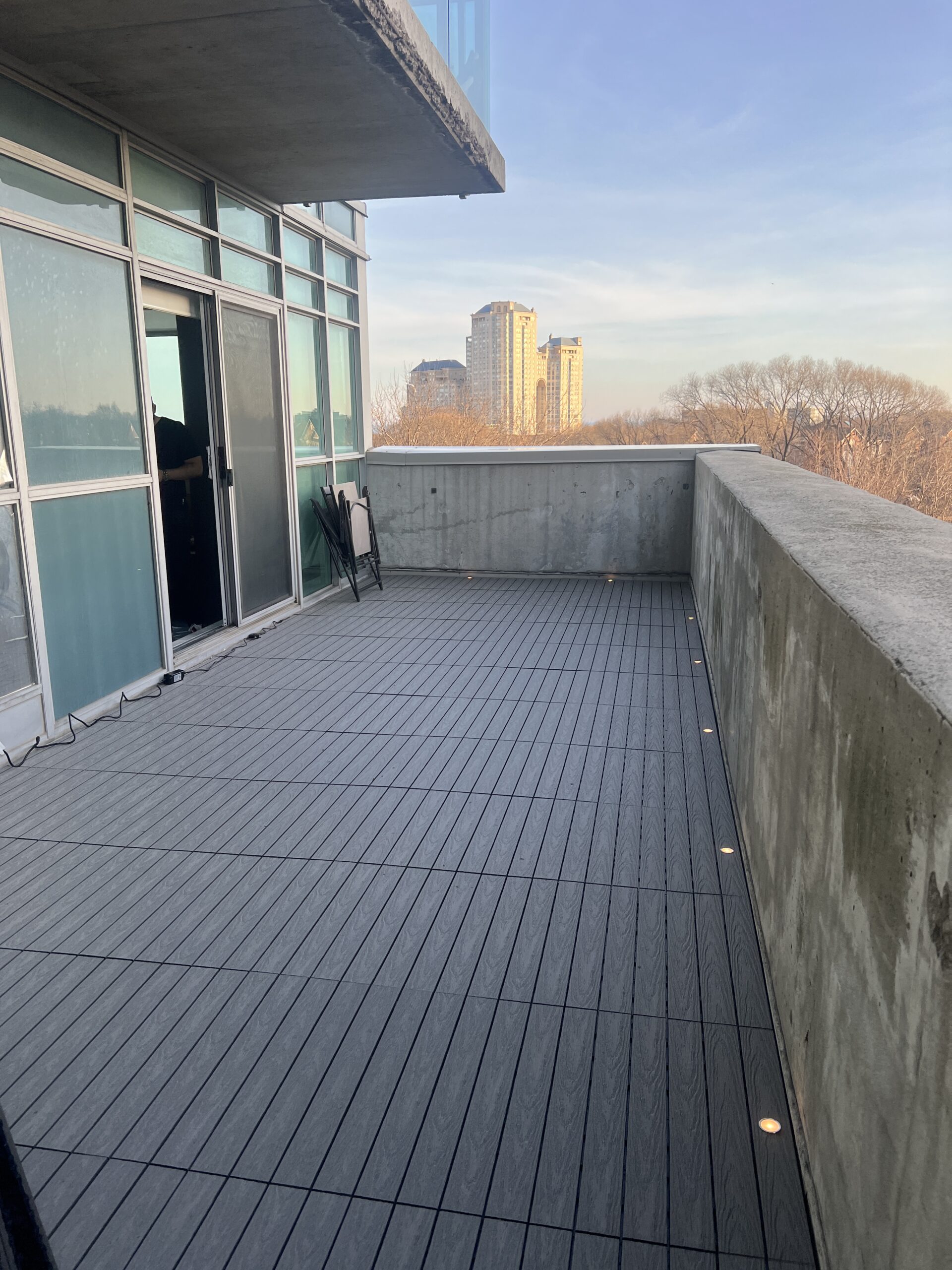 Modern condo balcony in Etobicoke featuring Light Grey 1x2 WPC deck tiles and integrated balcony deck lights.