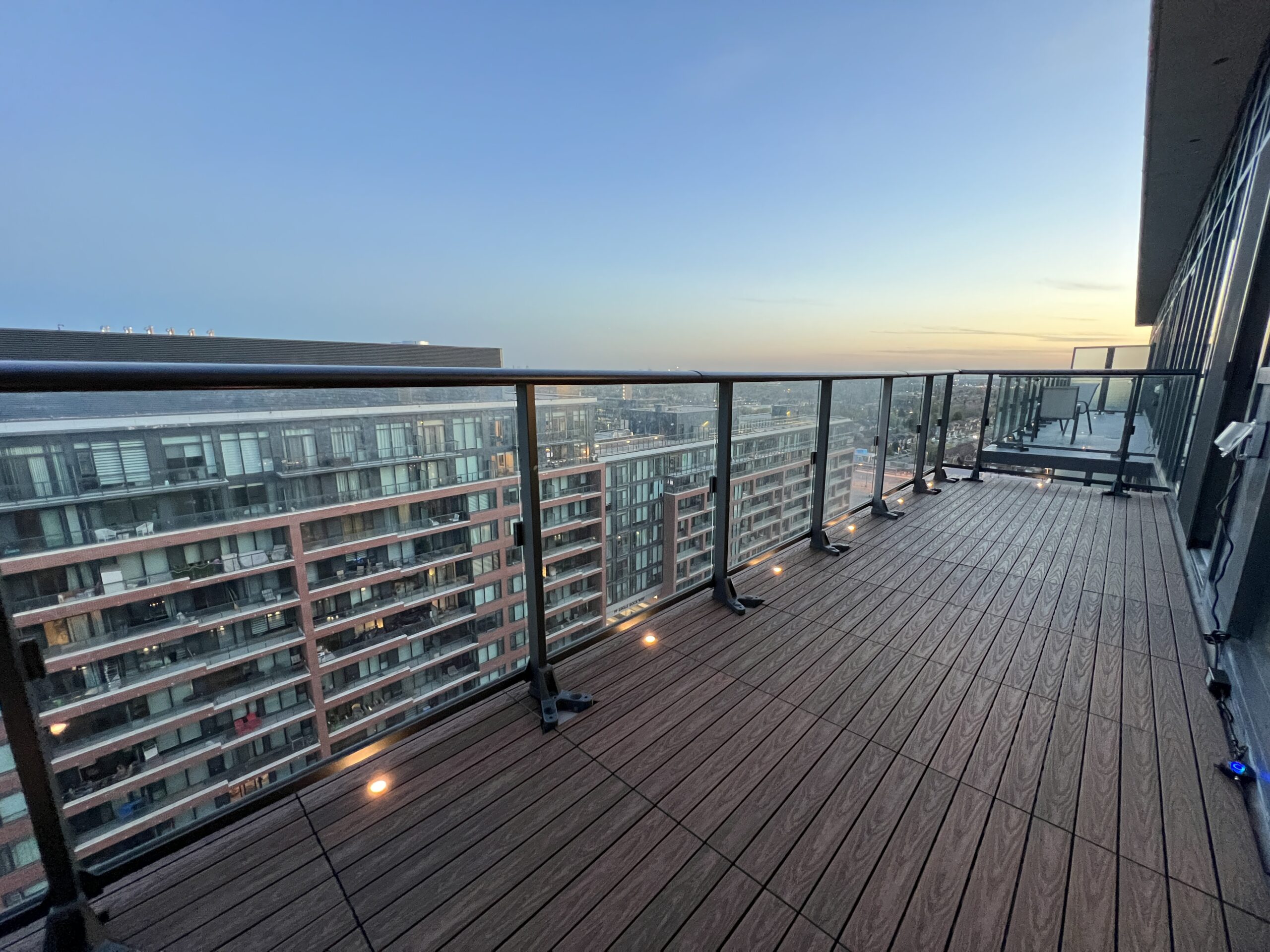 IPE 1x2 WPC deck tiles installed in a linear pattern on an open condo balcony in Vaughan, featuring built-in deck lights