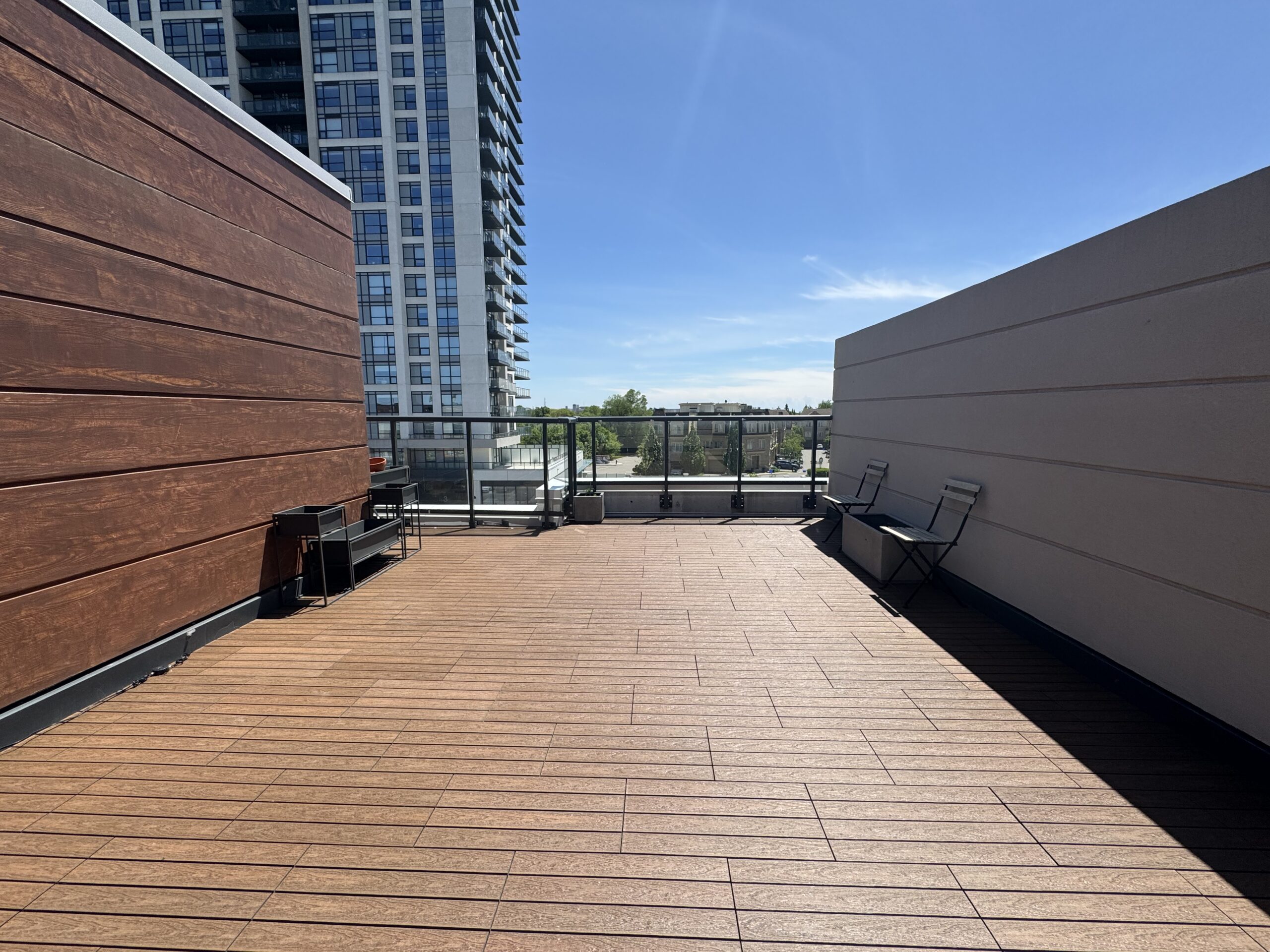 Teak 1x2 WPC deck tiles installed in a staggered pattern on a rooftop terrace of a townhouse in Ajax, complete with deck lights