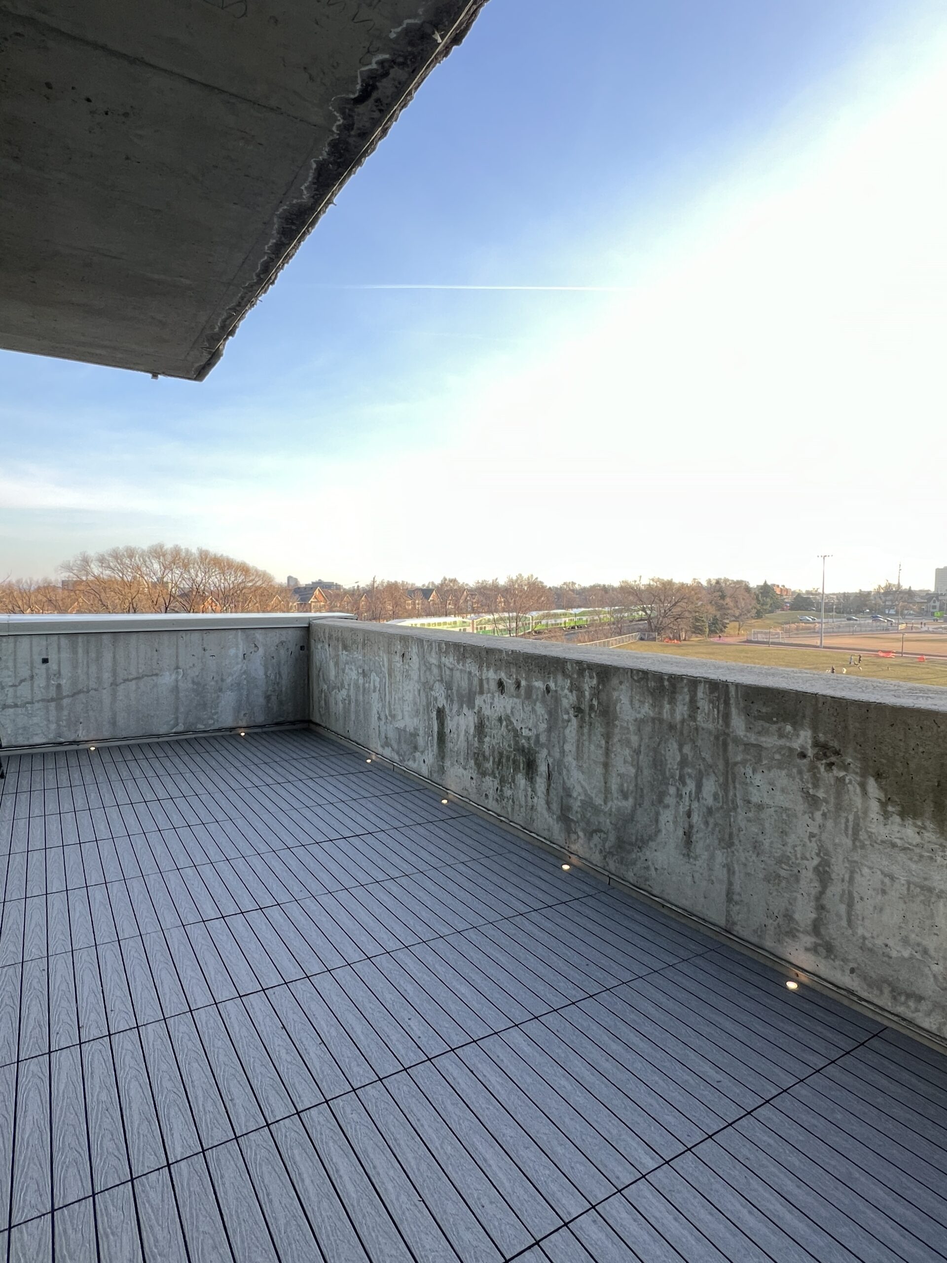 Modern condo balcony in Etobicoke featuring Light Grey 1x2 WPC deck tiles and integrated balcony deck lights.