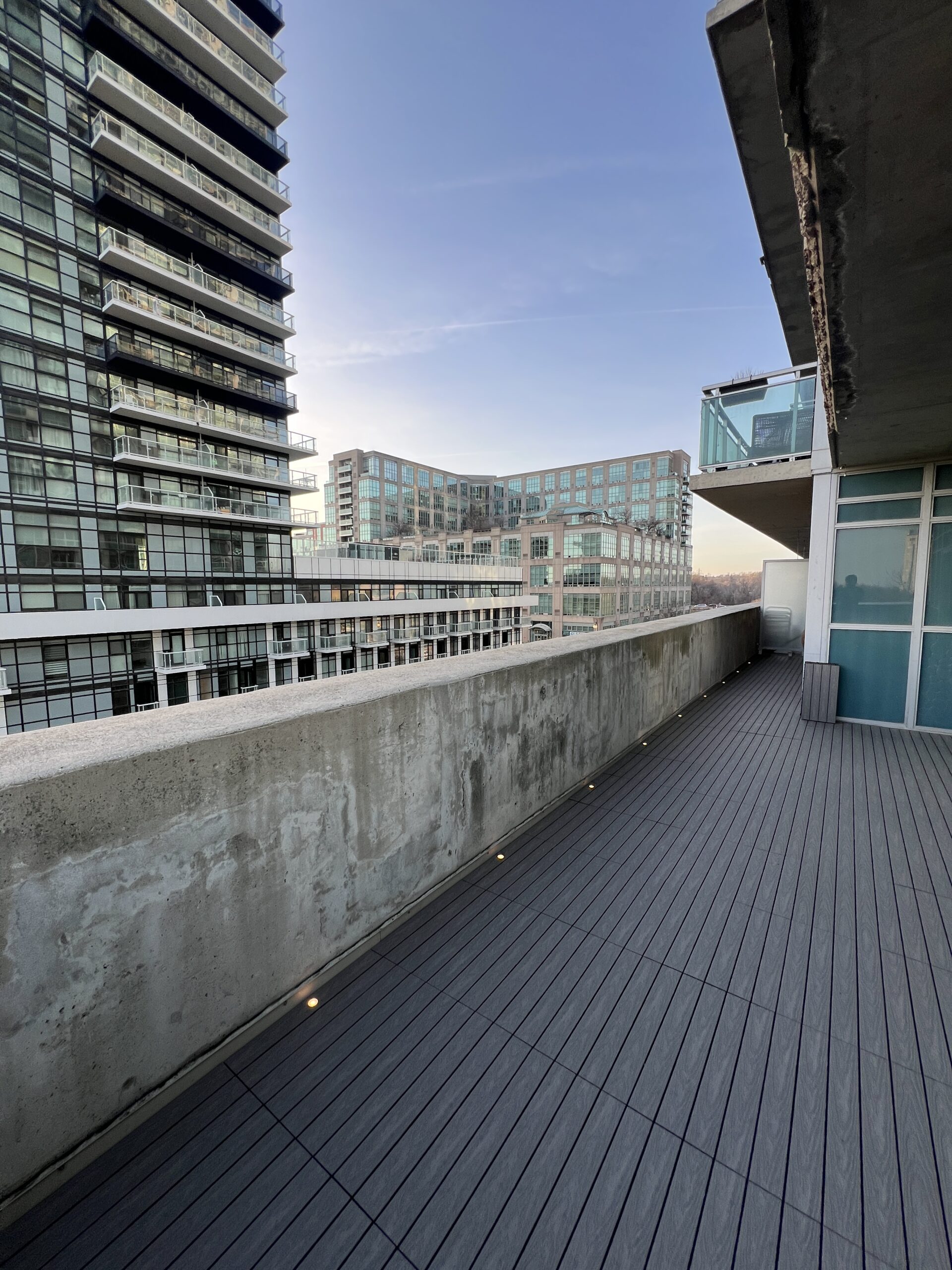 Modern condo balcony in Etobicoke featuring Light Grey 1x2 WPC deck tiles and integrated balcony deck lights.